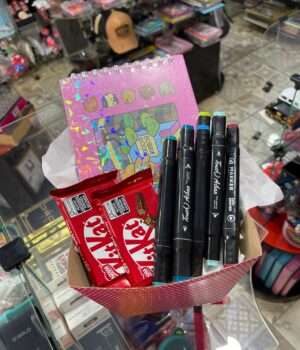 CESTA COM CADERNO BOBBIE GOODS + 8 CANETINHAS DE DUAS PONTAS + 2 KITKAT